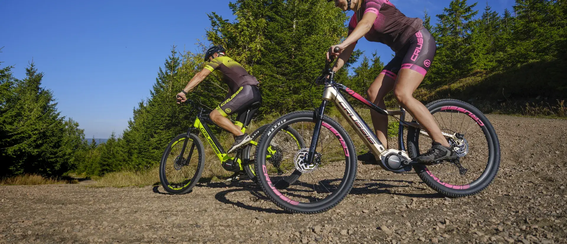 Dva cyklisté na elektrokolech Crussis na šotolinové cestě